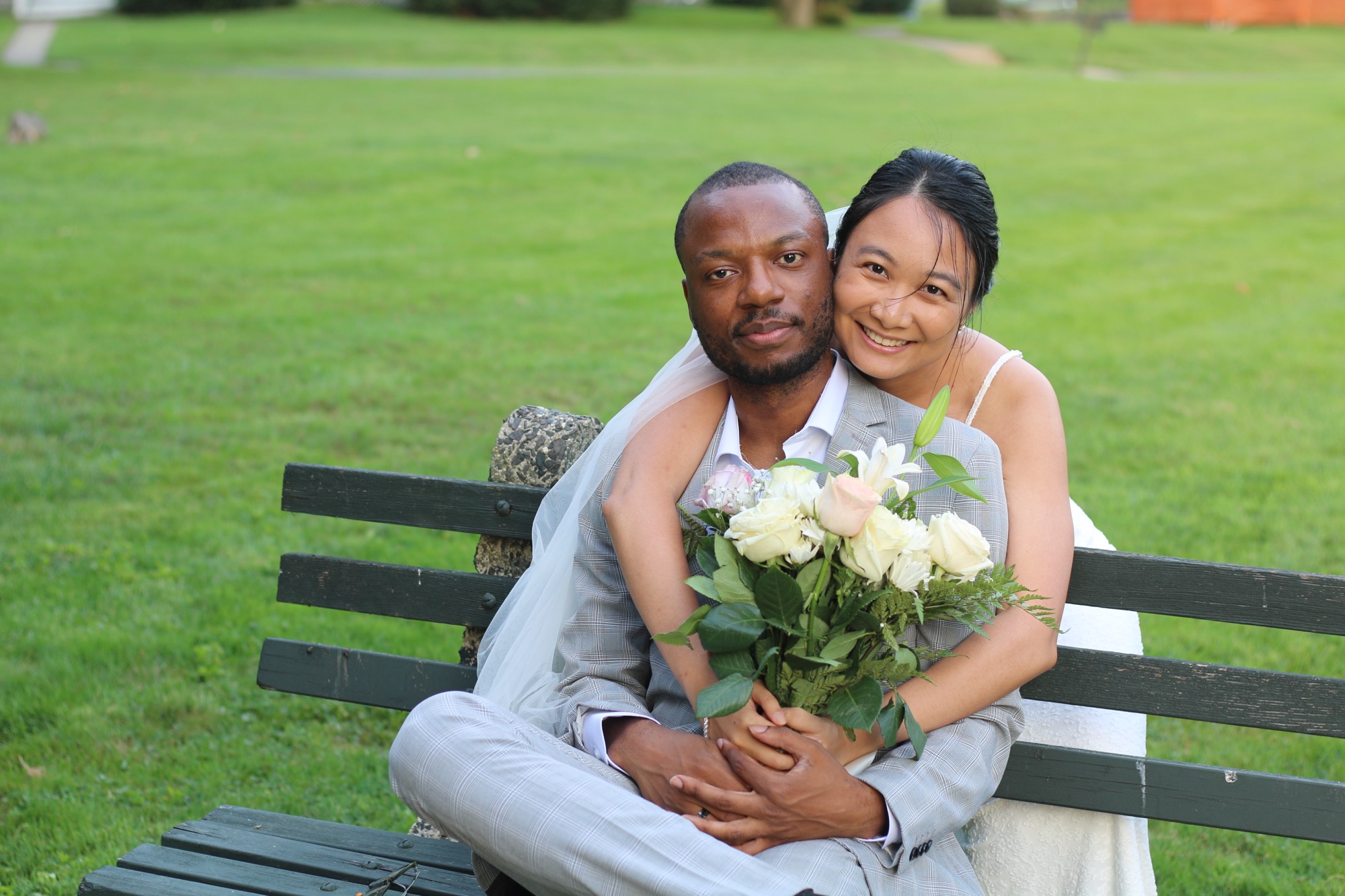 Krishel and Omar look at each other in a garden of orange flowers. Krishel holds a bouquet of white roses.